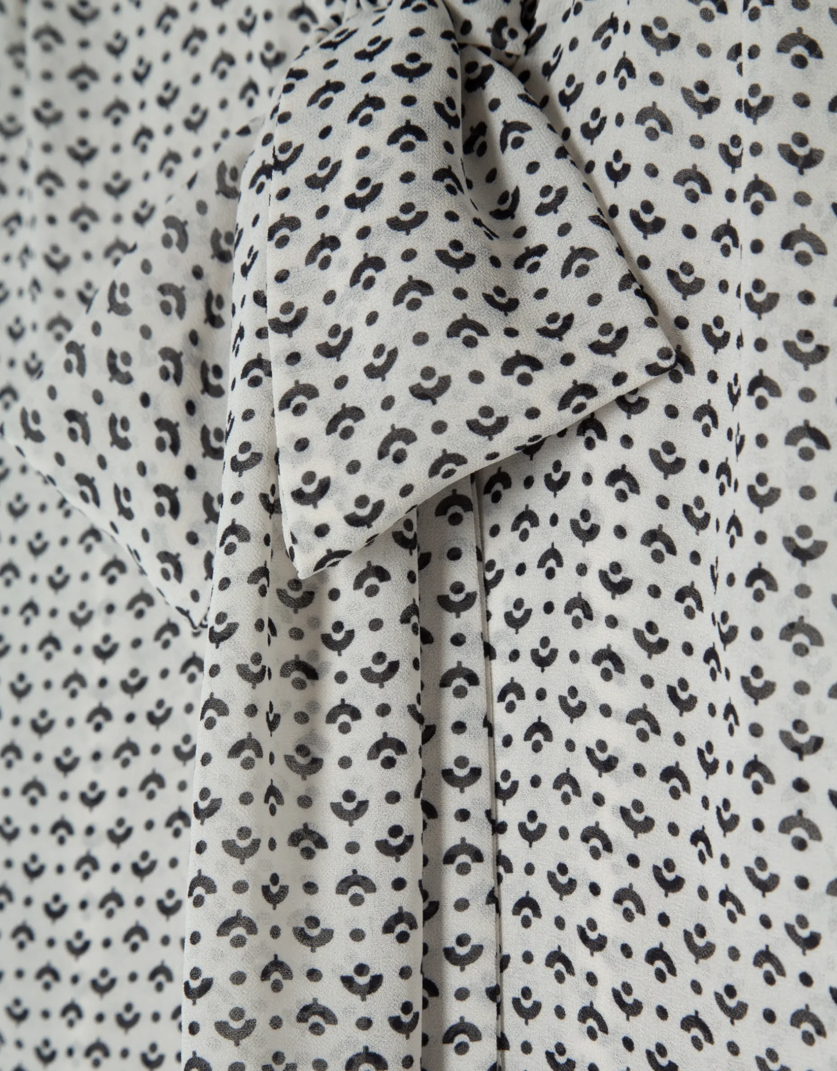 Blusa con lazada estampado geométrico blanco y negro